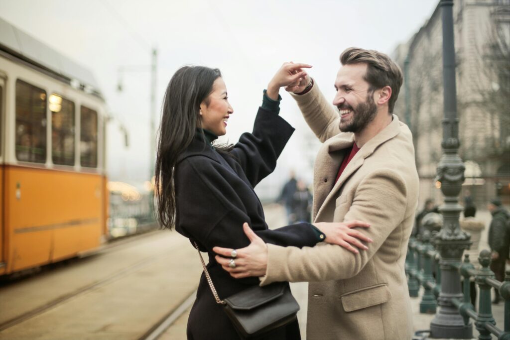 A Happy Couple Dancing On Sidewalk
