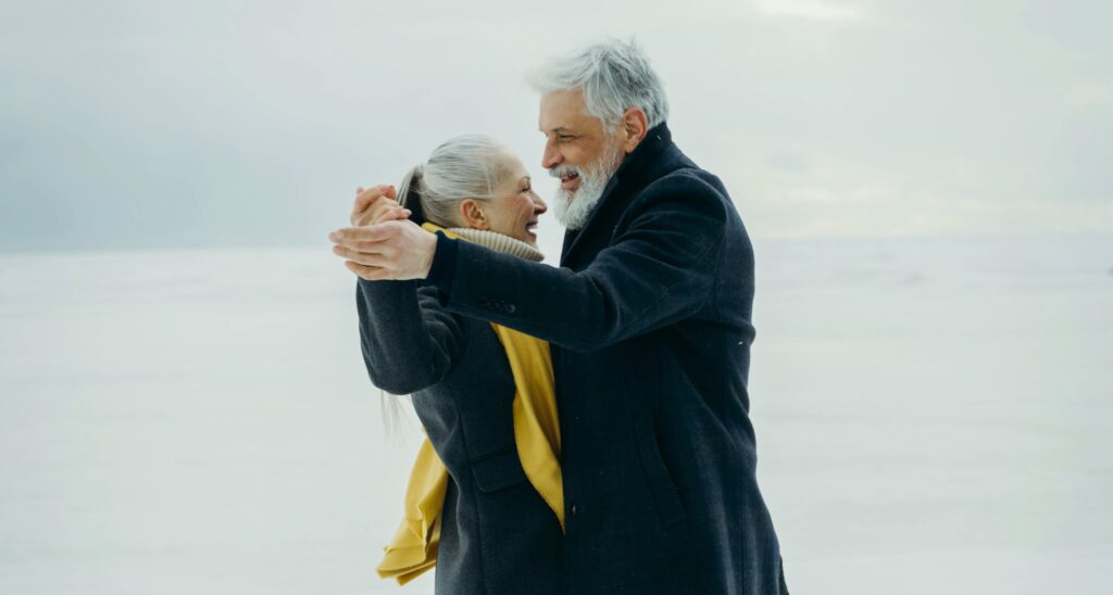 Older Polyamorous Couple Dancing on Snow
