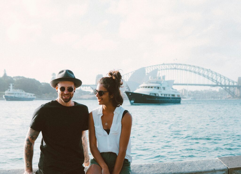 Man and Woman Sitting on Bench Beside Body of Water
