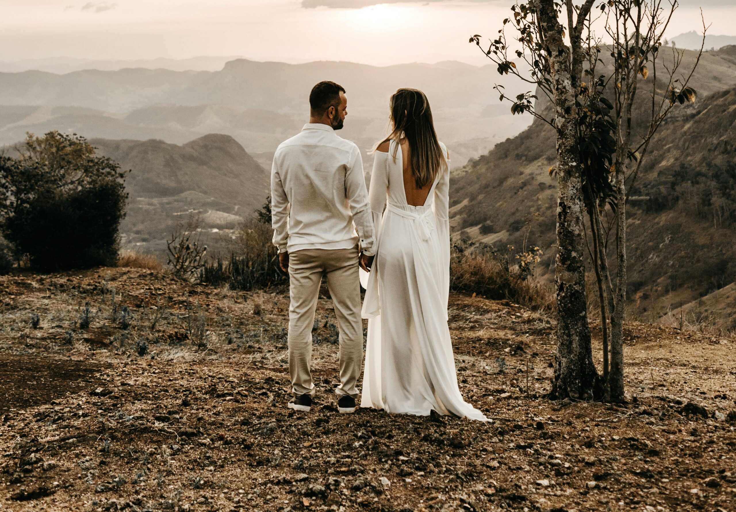 Polyamorous man and woman holding hands near a mountain