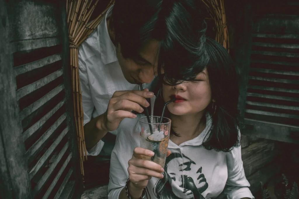 Man and Woman Sipping in Drinking Glass