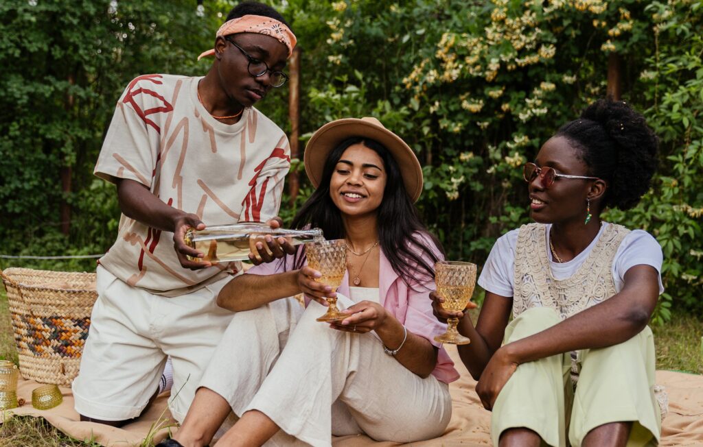 Three Polyamorous Friends Sitting in Woods and Drinking Wine
