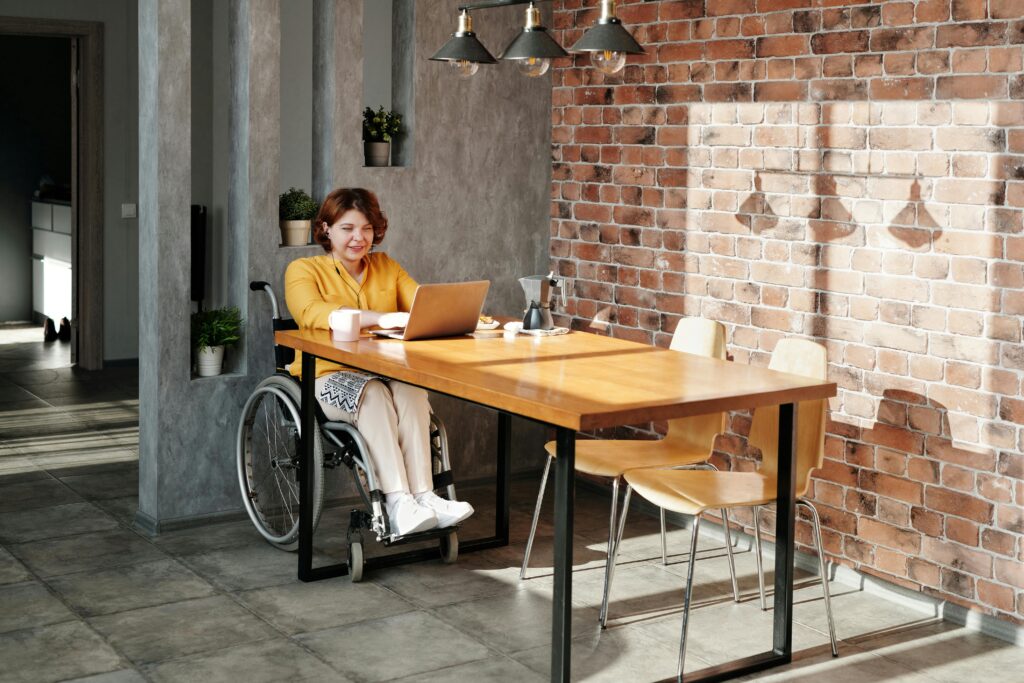 Woman Sitting on Wheelchair While Using Laptop
