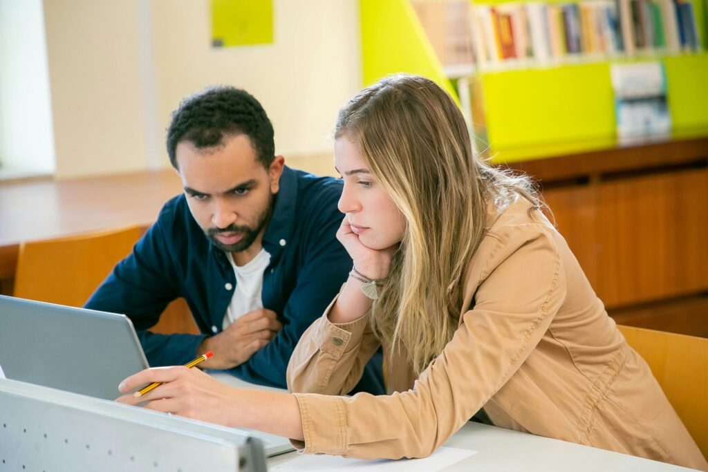 Multiethnic students doing homework together in library