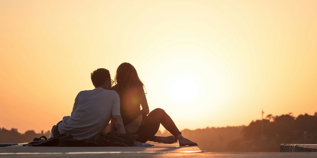 couple sitting near trees during golden hour