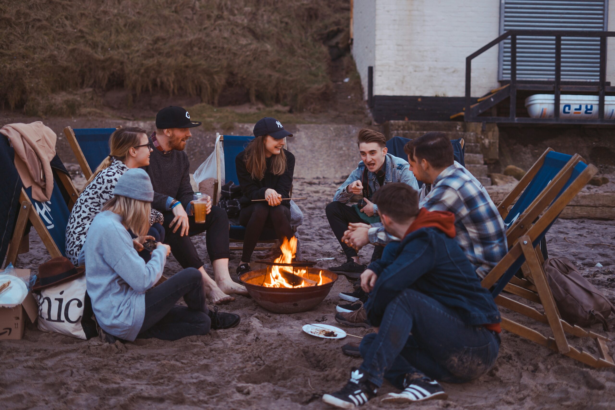 group of polyamorous people sitting on front firepit