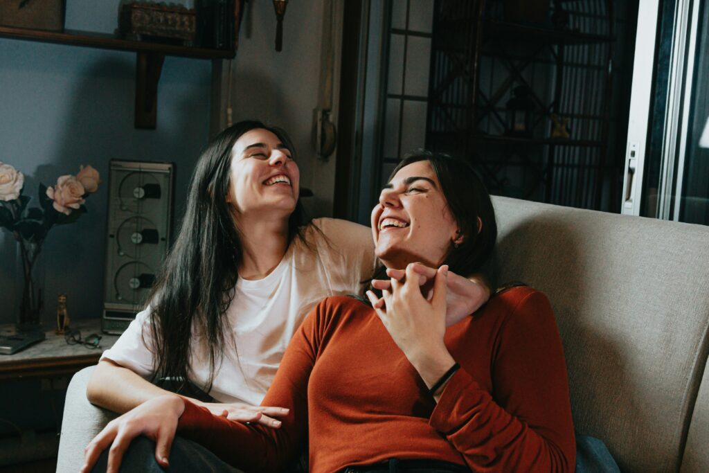 woman sitting beside woman in white long sleeve shirt