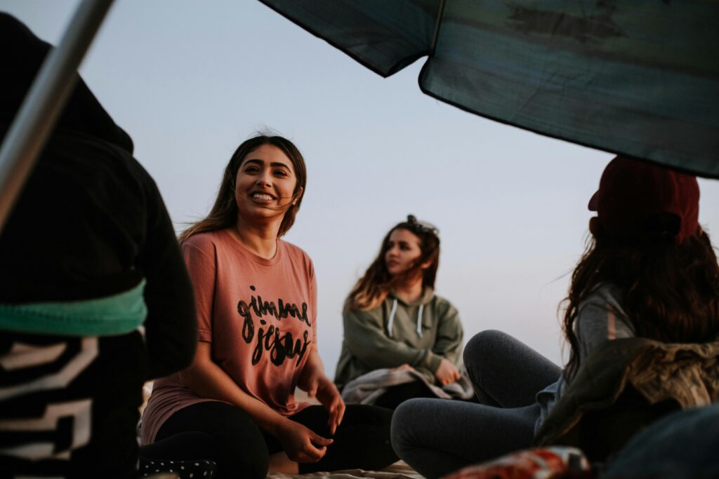 three women sitting near patio umbrella