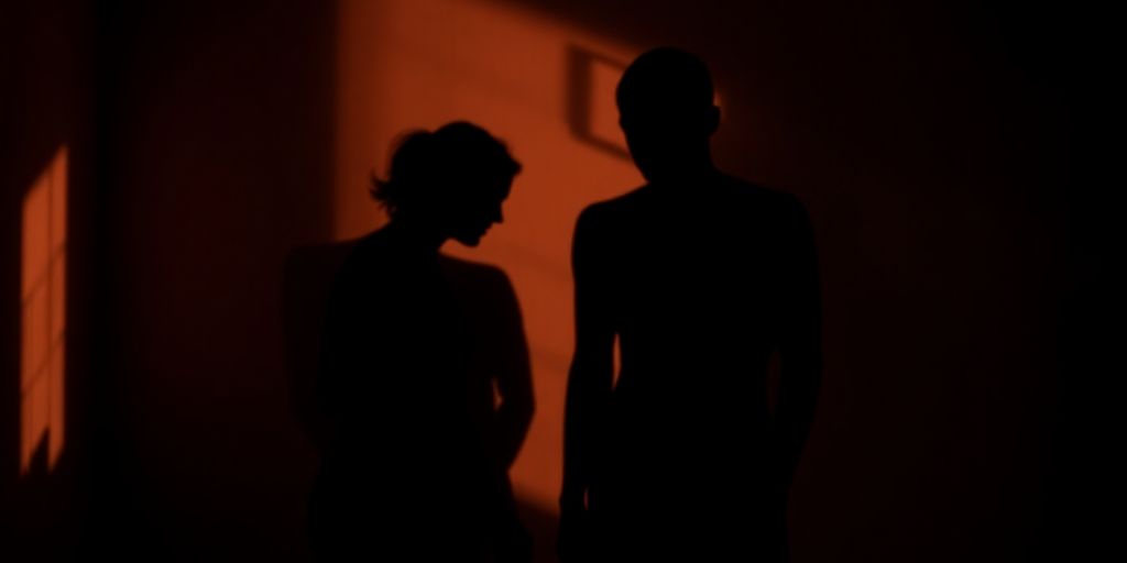 Three figures in a dimly lit, intimate setting.