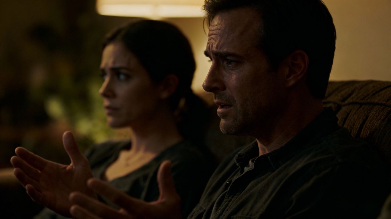 Couple arguing on a couch, looking stressed.