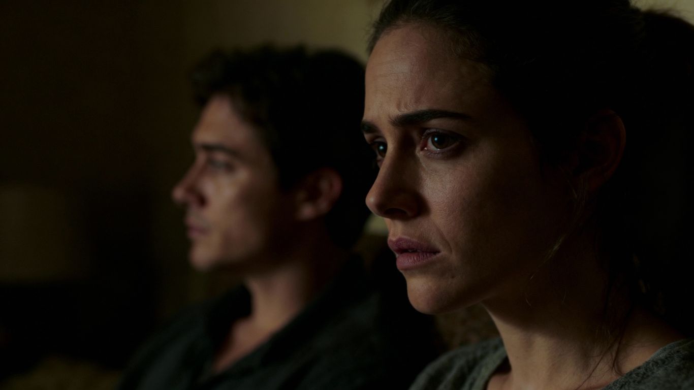 Couple in a room, one partner looking away.